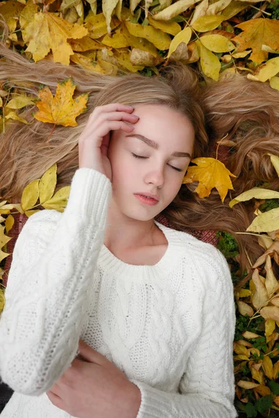 美しさ 健康の概念 かわいい女の子 黄色の秋葉に横たわっています — ストック写真