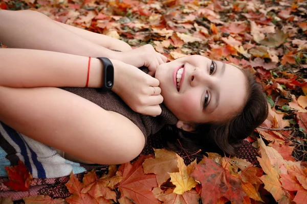 Güzellik, insanlar, sezon ve sağlık kavramı - sevimli küçük kız sarı sonbahar yaprak yalan söylüyor