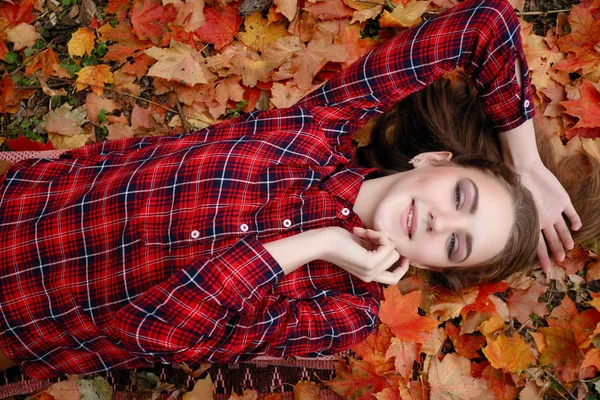 Güzellik, insanlar, sezon ve sağlık kavramı - kırmızı sonbahar yaprakları sarı renk ile güzel kız yalan söylüyor