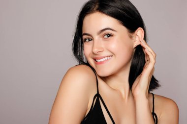 Güzel bir kadınla mükemmel cilt ve gri arka plan üzerinde çıplak omuz