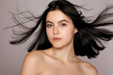 Güzel bir kadınla mükemmel cilt ve gri arka plan üzerinde çıplak omuz