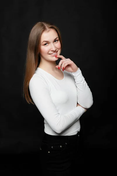 Youth, lifestyle and education concept. image of young hipster girl wearing blank white t-shirt and black jeans, black background.