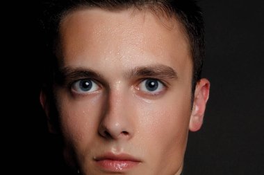 İzole yakışıklı delikanlı. Güzellik portre gömleksiz kaslı adamın siyah arka plan üzerinde duran ve kameraya bakıyor. Erkek Sağlığı.