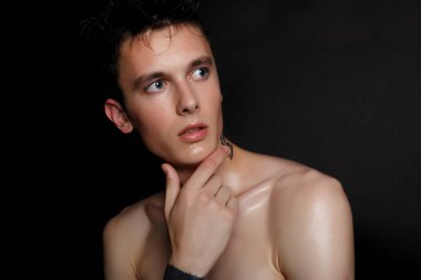 İzole yakışıklı delikanlı. Güzellik portre gömleksiz kaslı adamın siyah arka plan üzerinde duran ve kameraya bakıyor. Erkek Sağlığı.