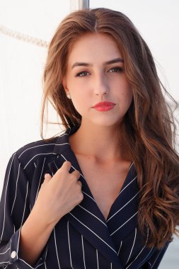 Çekici kız yaz gününde bir yatta. Yat poz çarpıcı romantik kadın moda portresi kapatın. Bir zarif elbise, yaz kıyafeti giyiyor. Mavi gökyüzü. günbatımı