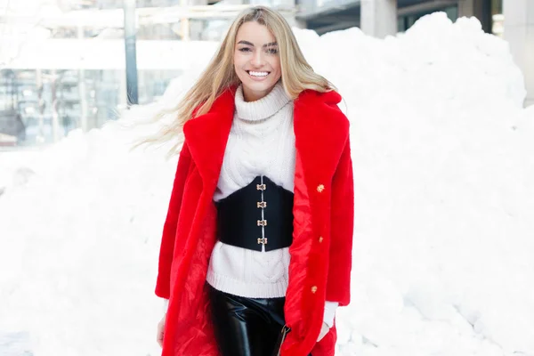 ファッション コンセプト 美しい若い女性の肖像画が赤い毛皮コート クローズ アップ雪寒い冬を笑顔市を歩くファッションの人 霜で新鮮な空気冬の日 サンセット — ストック写真