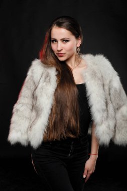 Lüks kürk paltolu uzun kahverengi saçlı kız. Kar kraliçesi. Soğuk kız. Vaşak, kürk, moda, güzellik. Rüzgar, koyu arka plan. Kürk salon, Kuzey