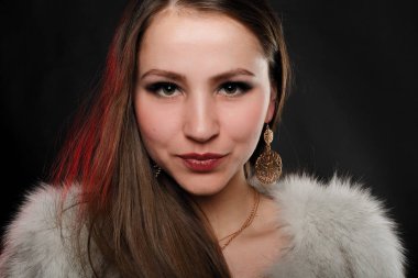 Lüks kürk paltolu uzun kahverengi saçlı kız. Kar kraliçesi. Soğuk kız. Vaşak, kürk, moda, güzellik. Rüzgar, koyu arka plan. Kürk salon, Kuzey