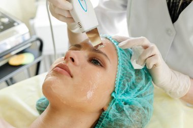 insanlar, Güzellik, spa, kozmetik ve teknoloji kavramı - güzellik uzmanı yordamı ultrasonik yüz peeling güzel, Genç bir kadının yüz derisinin bir güzellik salonu yapar.
