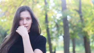 Güzel genç kadının saçları ile oynamak portre. Kız deri altına gider. Doğal makyaj ve onun uzun Rüzgar saçlarında kamera bakarken hareket sıralama ile genç ve güzel kız