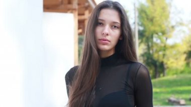 Güzel genç kadının saçları ile oynamak portre. Kız deri altına gider. Doğal makyaj ve onun uzun Rüzgar saçlarında kamera bakarken hareket sıralama ile genç ve güzel kız