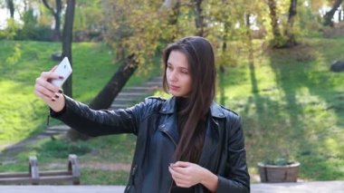 Güzel genç kadının saçları ile oynamak portre. Kız deri altına gider. Doğal makyaj ve onun uzun Rüzgar saçlarında kamera bakarken hareket sıralama ile genç ve güzel kız