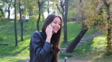 Güzel genç kadının saçları ile oynamak portre. Kız deri altına gider. Doğal makyaj ve onun uzun Rüzgar saçlarında kamera bakarken hareket sıralama ile genç ve güzel kız