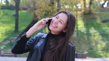 Güzel genç kadının saçları ile oynamak portre. Kız deri altına gider. Doğal makyaj ve onun uzun Rüzgar saçlarında kamera bakarken hareket sıralama ile genç ve güzel kız