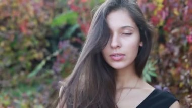 Güzel genç kadının saçları ile oynamak portre. Doğal makyaj ve onun uzun Rüzgar saçlarında kamera bakarken hareket sıralama ile genç ve güzel kız