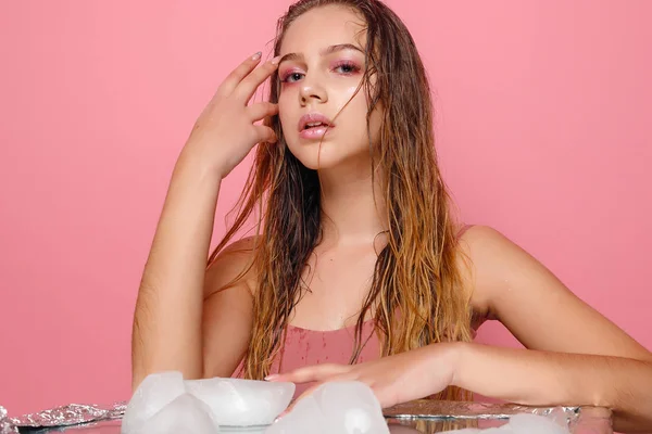 Jeune femme applique la glace sur un fond rose . — Photo