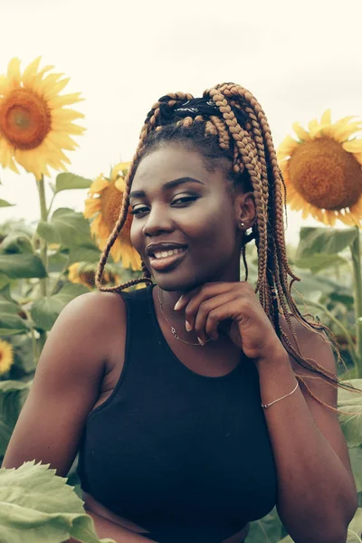 Menina afro-americana em um campo de flores amarelas ao pôr do sol — Fotografia de Stock