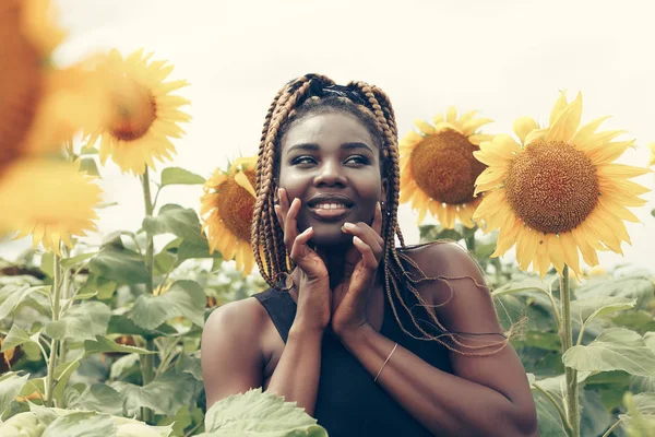 Afro-Américaine dans un champ de fleurs jaunes au coucher du soleil — Photo