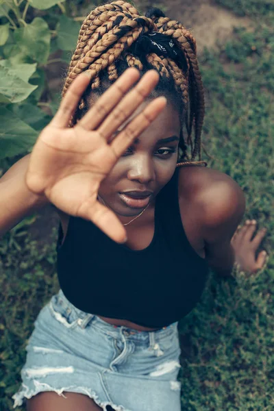 Menina afro-americana em um campo de flores amarelas ao pôr do sol — Fotografia de Stock