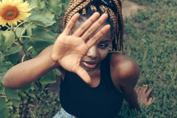 Menina afro-americana em um campo de flores amarelas ao pôr do sol — Fotografia de Stock