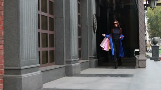 人的美丽和生活方式的概念 时尚的女性在斗篷走在城市街道上 美女在城里逛街 她很高兴在期间购物销售 — 图库视频影像