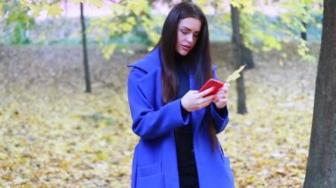 insanlar, güzellik ve yaşam tarzı kavramı - şehrin sokak yürüyüş şık kadın pelerin. güneşli şehir sokakları yürüyüş ve neşeli hippi kız açık havada cep telefonu kullanarak arkadaşlarınızla sohbet kadın
