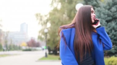 insanlar, güzellik ve yaşam tarzı kavramı - şehrin sokak yürüyüş şık kadın pelerin. güneşli şehir sokakları yürüyüş ve neşeli hippi kız açık havada cep telefonu kullanarak arkadaşlarınızla sohbet kadın