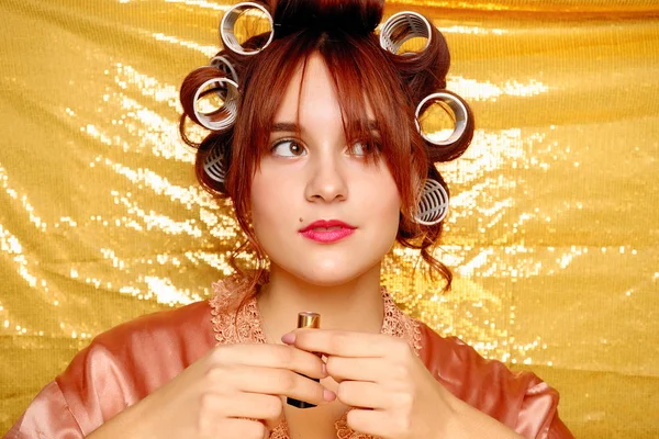 Menina bonita em encrespadores de cabelo isolado em ouro — Fotografia de Stock