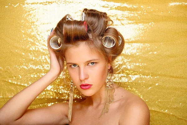 Menina bonita em encrespadores de cabelo isolado em ouro — Fotografia de Stock