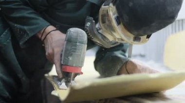 Meslek, insanlar, marangozluk, duygu ve insanlar kavramı-bir marangoz bir elektrikli jigsaw ile bir tahta keser. pateboardlar imalatı. Koruyucu Giyim ve maske vardır. 4k