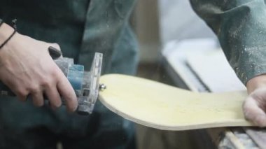 Meslek, insanlar marangozluk, duygu ve insanlar kavramı - genç esnaf adam sandering sandering aracı ile refocusing güverte. kaykaylar imalatı. o koruyucu kıyafet ve maske vardır. 4k