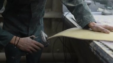 Meslek, insanlar marangozluk, duygu ve insanlar kavramı - genç esnaf adam sandering sandering aracı ile refocusing güverte. kaykaylar imalatı. o koruyucu kıyafet ve maske vardır. 4k