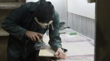 Meslek, insanlar marangozluk, duygu ve insanlar kavramı - genç esnaf adam sandering sandering aracı ile refocusing güverte. kaykaylar imalatı. o koruyucu kıyafet ve maske vardır. 4k