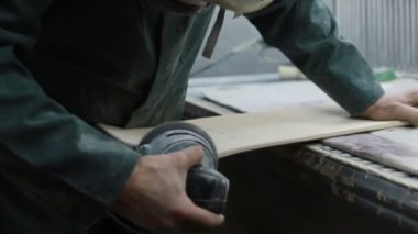 Meslek, insanlar marangozluk, duygu ve insanlar kavramı - genç esnaf adam sandering sandering aracı ile refocusing güverte. kaykaylar imalatı. o koruyucu kıyafet ve maske vardır. 4k