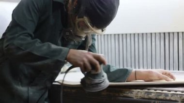 Meslek, insanlar marangozluk, duygu ve insanlar kavramı - genç esnaf adam sandering sandering aracı ile refocusing güverte. kaykaylar imalatı. o koruyucu kıyafet ve maske vardır. 4k