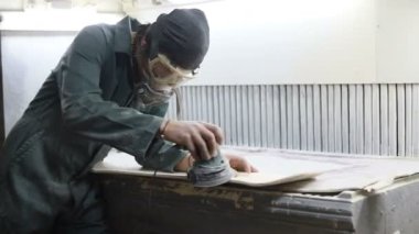 Meslek, insanlar marangozluk, duygu ve insanlar kavramı - genç esnaf adam sandering sandering aracı ile refocusing güverte. kaykaylar imalatı. o koruyucu kıyafet ve maske vardır. 4k