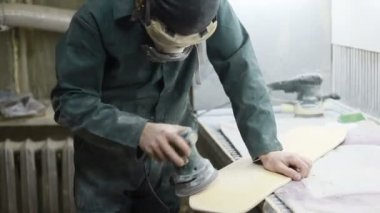 Meslek, insanlar marangozluk, duygu ve insanlar kavramı - genç esnaf adam sandering sandering aracı ile refocusing güverte. kaykaylar imalatı. o koruyucu kıyafet ve maske vardır. 4k