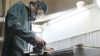 Meslek, insanlar marangozluk, duygu ve insanlar kavramı - genç esnaf adam sandering sandering aracı ile refocusing güverte. kaykaylar imalatı. o koruyucu kıyafet ve maske vardır. 4k
