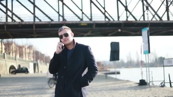 Молодой Привлекательный Бизнесмен Разговаривает Телефону Прогуливаясь Улице Задний Вид Элегантного — стоковое видео