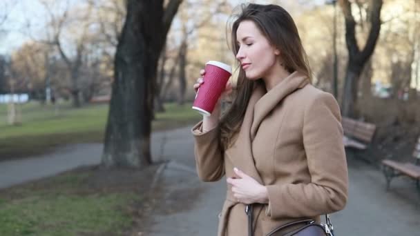 사람들의 여자나 소녀가길가 벤치에 컵에서 커피를 마시는 — 비디오