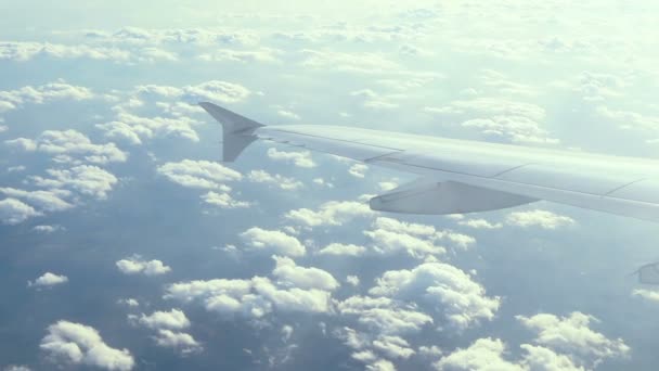 从蓝天的飞机窗口 在云层上方看到鸟图的令人惊叹的画面 从天空中通过云层看到了地球 空中镜头 旅游理念 — 图库视频影像