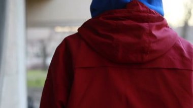 Kar maskeli, kimliği belirsiz genç adam duvarın yanında duruyor ve elinde sprey boya tutuyor. Vandalizm, sokak sanatı, hobi. Banliyö bölgesi, eğlence, isyan, protesto. Görüntüyü kapat
