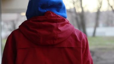 Kar maskeli, kimliği belirsiz genç adam duvarın yanında duruyor ve elinde sprey boya tutuyor. Vandalizm, sokak sanatı, hobi. Banliyö bölgesi, eğlence, isyan, protesto. Görüntüyü kapat