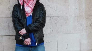 Kar maskeli, kimliği belirsiz genç adam duvarın yanında duruyor ve elinde sprey boya tutuyor. Vandalizm, sokak sanatı, hobi. Banliyö bölgesi, eğlence, isyan, protesto. Görüntüyü kapat