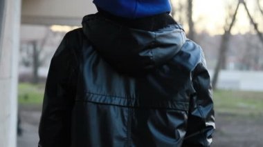 Kar maskeli, kimliği belirsiz genç adam duvarın yanında duruyor ve elinde sprey boya tutuyor. Vandalizm, sokak sanatı, hobi. Banliyö bölgesi, eğlence, isyan, protesto. Görüntüyü kapat