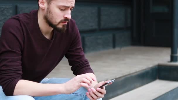 Hombre Retrato Sentado Uso Teléfono Mirando Hacia Los Lados Sonrisa — Vídeo de stock