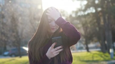 Güneşli şehir sokakları yürüyüş ve sohbet arkadaş, neşeli hippi kız açık havada cep telefonu kullanarak, gün batımı arka plan ile çekici genç kadın