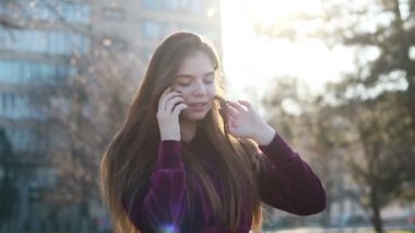 Güneşli şehir sokakları yürüyüş ve sohbet arkadaş, neşeli hippi kız açık havada cep telefonu kullanarak, gün batımı arka plan ile çekici genç kadın