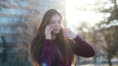 Güneşli şehir sokakları yürüyüş ve sohbet arkadaş, neşeli hippi kız açık havada cep telefonu kullanarak, gün batımı arka plan ile çekici genç kadın
