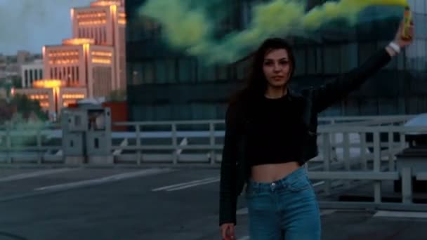 女性は緊急フレア信号を作る 煙の爆弾を持つヒップスターの女の子 屋上駐車場の日没時に煙の手榴弾で外の若い女性 — ストック動画